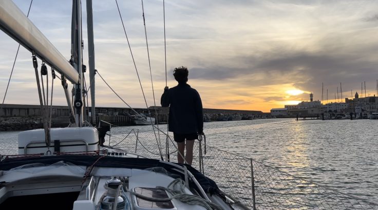 Velero entrando en el puerto de Rota al atardecer, imagen utilizada para ilustrar un artÃ­culo sobre las oposiciones de Lengua 2026.